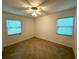 This is a bright bedroom with two windows, tile floor, and ceiling fan at 2315 Carroll Pl, Tampa, FL 33612