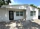 Close-up of the front exterior showing a white, one-story home and paver drive at 2315 Carroll Pl, Tampa, FL 33612
