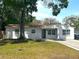 Inviting one-story home featuring a brick-paved driveway and mature tree at 2315 Carroll Pl, Tampa, FL 33612