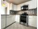 Updated kitchen featuring stainless steel appliances, stone backsplash, and white cabinetry at 2315 Carroll Pl, Tampa, FL 33612