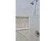 Modern shower with marble-patterned tiling, shower-head, and built-in shelving niche at 2315 Carroll Pl, Tampa, FL 33612