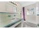 Bathroom with blue and white tile, tub and shower, and vanity with countertop at 2418 N Links Ave, Sarasota, FL 34234