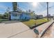Exterior shot of light blue home, showcasing the driveway and lawn at 2418 N Links Ave, Sarasota, FL 34234