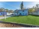 Charming light blue home featuring a well-maintained lawn and inviting front porch at 2418 N Links Ave, Sarasota, FL 34234