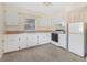 Bright kitchen features white cabinetry, window over sink, and standard appliances at 2418 N Links Ave, Sarasota, FL 34234