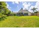 Beautiful backyard view of the home, lush green grass, and privacy fencing at 29013 Old Marsh End, Wesley Chapel, FL 33543