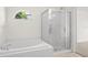 Bright bathroom featuring a tub and a glass shower with white tile and modern fixtures at 29013 Old Marsh End, Wesley Chapel, FL 33543