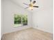 Well-lit bedroom with a ceiling fan, wood look tile flooring and a large window at 29013 Old Marsh End, Wesley Chapel, FL 33543