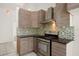 Modern kitchen features stainless steel appliances, granite countertops, and tile backsplash at 29013 Old Marsh End, Wesley Chapel, FL 33543