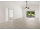 Bright living room features tile floors, a fan, and sliding glass doors with a view of the outdoors at 29013 Old Marsh End, Wesley Chapel, FL 33543