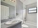 Bathroom showcasing a single sink vanity, toilet, and tub with tiled walls and a window at 2974 Sean Way, Palm Harbor, FL 34684