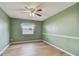 Cozy bedroom featuring a ceiling fan, neutral decor, and wood-look laminate flooring at 2974 Sean Way, Palm Harbor, FL 34684