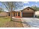 Inviting home with a two-car garage, manicured lawn, and vibrant landscaping enhancing curb appeal at 2974 Sean Way, Palm Harbor, FL 34684