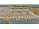 Aerial view of a residential community featuring multiple homes, a lake, and green spaces at 33645 Elm Hill Br, Wesley Chapel, FL 33545
