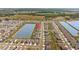 Aerial view of a community with homes surrounding a lake, highlighting the neighborhood's scenery at 33645 Elm Hill Br, Wesley Chapel, FL 33545