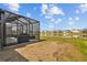 Beautiful backyard view featuring a screened-in lanai, pond view, and ample space at 33645 Elm Hill Br, Wesley Chapel, FL 33545