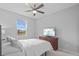 Clean bedroom with ceiling fan, a window overlooking pond and dresser with a TV at 33645 Elm Hill Br, Wesley Chapel, FL 33545