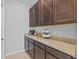 Cozy coffee bar area with granite countertops, dark cabinets, and coffee maker on display at 33645 Elm Hill Br, Wesley Chapel, FL 33545