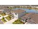 Aerial view of a two-story home with manicured landscaping, a porch, and a tranquil lake view at 33645 Elm Hill Br, Wesley Chapel, FL 33545