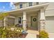 Inviting front porch with stone accents, a seating area, and a charming green front door at 33645 Elm Hill Br, Wesley Chapel, FL 33545