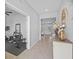 Bright hallway showcasing stylish tile flooring leading to a bonus room with workout equipment and an inviting living space at 33645 Elm Hill Br, Wesley Chapel, FL 33545