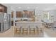 Kitchen featuring a granite island with seating, stainless steel appliances, and dark wood cabinets at 33645 Elm Hill Br, Wesley Chapel, FL 33545