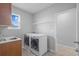 Well-equipped laundry room with modern appliances and overhead shelving provides ample space for laundry tasks at 33645 Elm Hill Br, Wesley Chapel, FL 33545