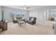 Spacious living room with large windows, modern furniture, and neutral carpet at 33645 Elm Hill Br, Wesley Chapel, FL 33545