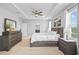 Well-lit main bedroom featuring tray ceilings and a large dresser with a mirror at 33645 Elm Hill Br, Wesley Chapel, FL 33545