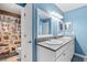 Bathroom with double sinks, blue walls, and shower curtain, adding a colorful touch at 3710 W Tacon St, Tampa, FL 33629