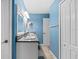 Bright bathroom with double vanity, neutral countertop, blue walls, and a mirrored medicine cabinet at 3710 W Tacon St, Tampa, FL 33629