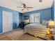 Sunny bedroom with blue walls, neutral carpet, white trim, and shuttered windows at 3710 W Tacon St, Tampa, FL 33629