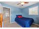 Cozy bedroom with blue walls and carpet, featuring a single bed and doorway to the hall at 3710 W Tacon St, Tampa, FL 33629
