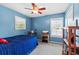Bright bedroom with a ceiling fan, blue walls, and large windows with plantation shutters at 3710 W Tacon St, Tampa, FL 33629