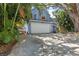 Two-story blue home with a two car garage and mature trees at 3710 W Tacon St, Tampa, FL 33629