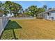 Spacious backyard with a white fence, lush greenery, and views of the house and screened-in lanai at 4419 Swift Cir, Valrico, FL 33596