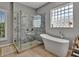 Bright bathroom showcasing a freestanding tub, glass block window, and marble-tiled shower at 4419 Swift Cir, Valrico, FL 33596