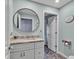 Powder room featuring a round mirror, granite countertop, and stylish herringbone tile floors at 4419 Swift Cir, Valrico, FL 33596