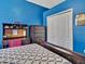 A blue bedroom is shown, including a closet, desk, dresser, and bed at 4419 Swift Cir, Valrico, FL 33596