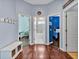 Hallway with three open doorways to bedrooms and bathroom; wood floors and bench at 4419 Swift Cir, Valrico, FL 33596