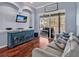 Comfortable living room with hardwood floors, a plush sofa, and sliding glass doors opening to the pool area at 4419 Swift Cir, Valrico, FL 33596