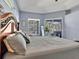 Bright and airy main bedroom with a large bed, soft gray accents, and access to the screened-in patio at 4419 Swift Cir, Valrico, FL 33596