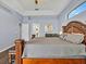 Spacious main bedroom featuring a decorative wood bed frame, tray ceiling, and light blue walls at 4419 Swift Cir, Valrico, FL 33596