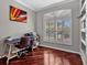 Home office featuring a large window with shutters, hardwood floors, and plenty of natural light at 4419 Swift Cir, Valrico, FL 33596