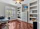 Bright home office with large window, custom built-in shelves, and gleaming hardwood floors at 4419 Swift Cir, Valrico, FL 33596