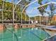 Inviting screened-in pool area with a serene waterfall feature and sunny white lounge chairs at 4419 Swift Cir, Valrico, FL 33596