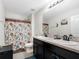 Bathroom featuring a double sink vanity, floral shower curtain, and neutral tile flooring at 5946 81St N Ave, Pinellas Park, FL 33781