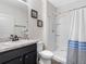 Bathroom features a sink with vanity, toilet, and a shower with a blue and white curtain at 5946 81St N Ave, Pinellas Park, FL 33781