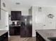 Well-lit kitchen featuring black cabinetry, granite countertops, and stainless steel refrigerator at 5946 81St N Ave, Pinellas Park, FL 33781