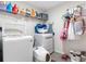 Functional laundry room with a washer, a dryer, and storage shelves for detergents and supplies at 5946 81St N Ave, Pinellas Park, FL 33781